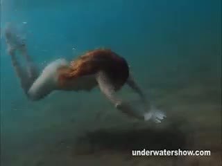 Julia es nadando bajo el agua desnuda en la mar